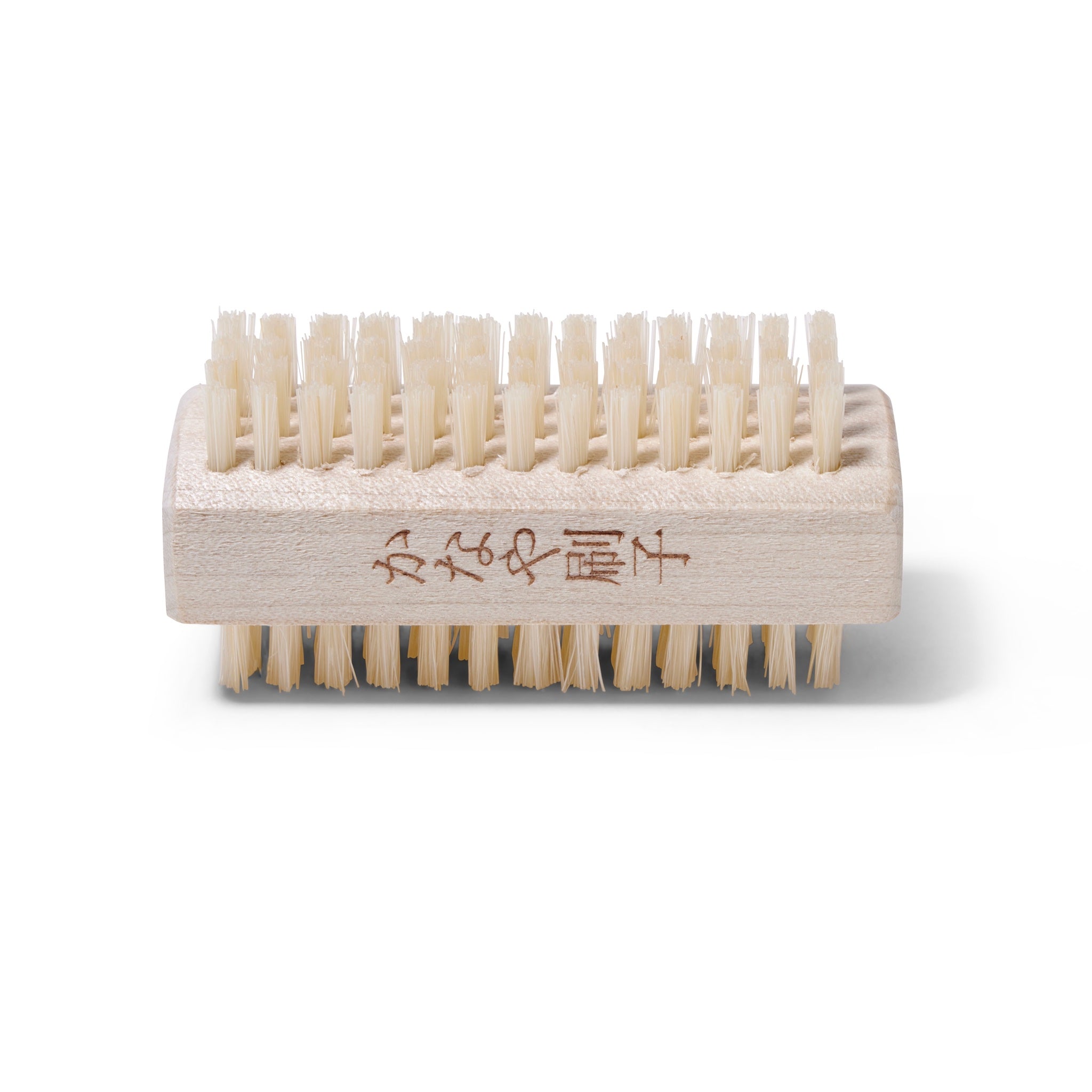 Side view of the dual sided Kanaya Nail Brush. The Brush is made of light colored boar bristles and light wood.