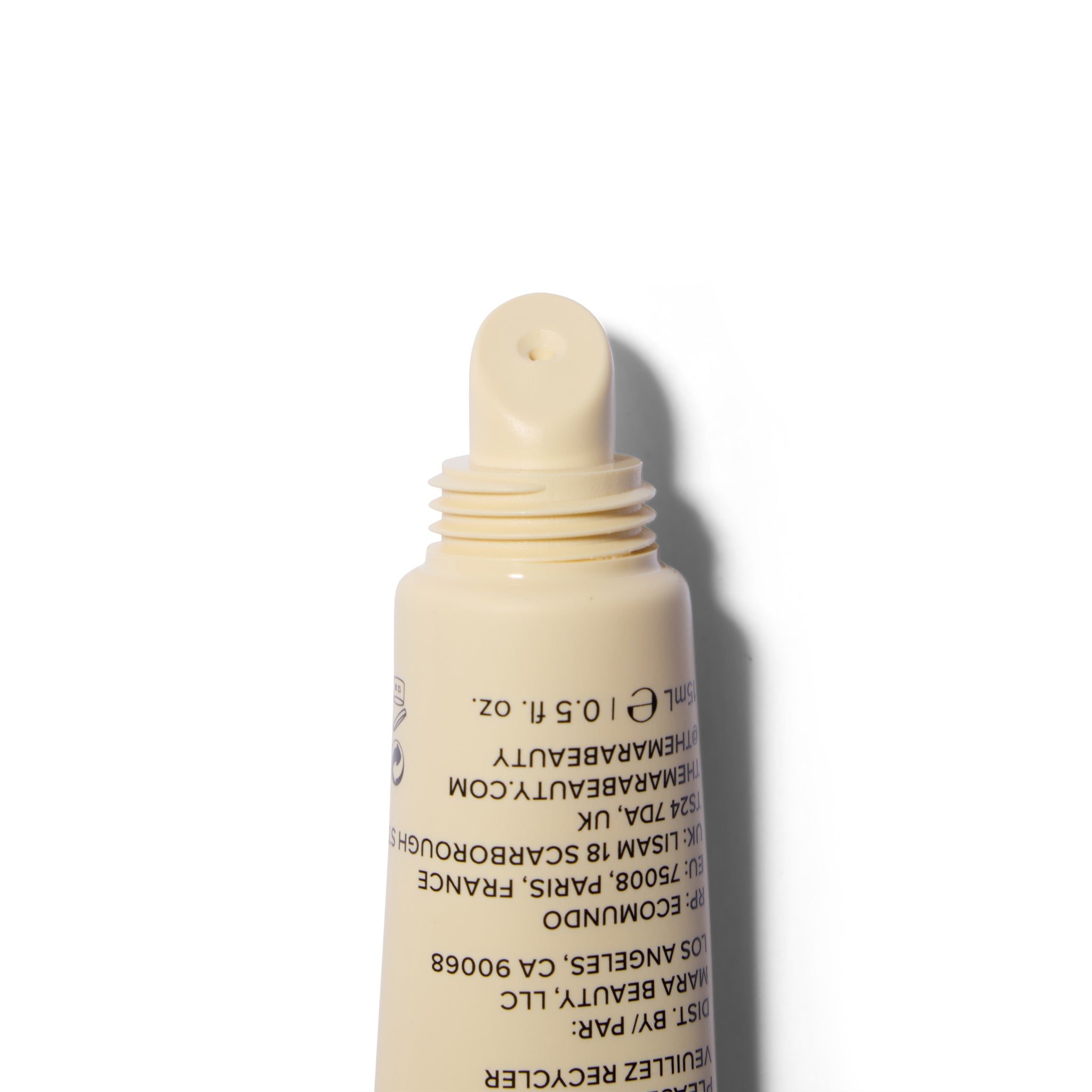 A close-up of a beige cosmetic tube with the cap off, showing printed black text on a white background.