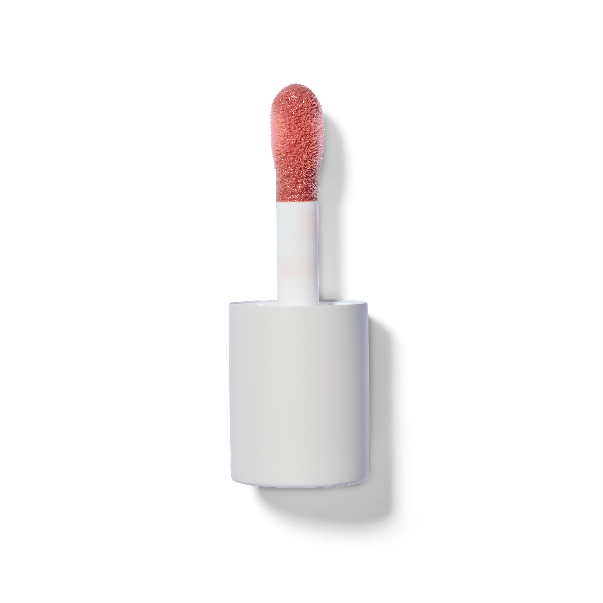 Lip gloss applicator with coral-colored tip on a white background