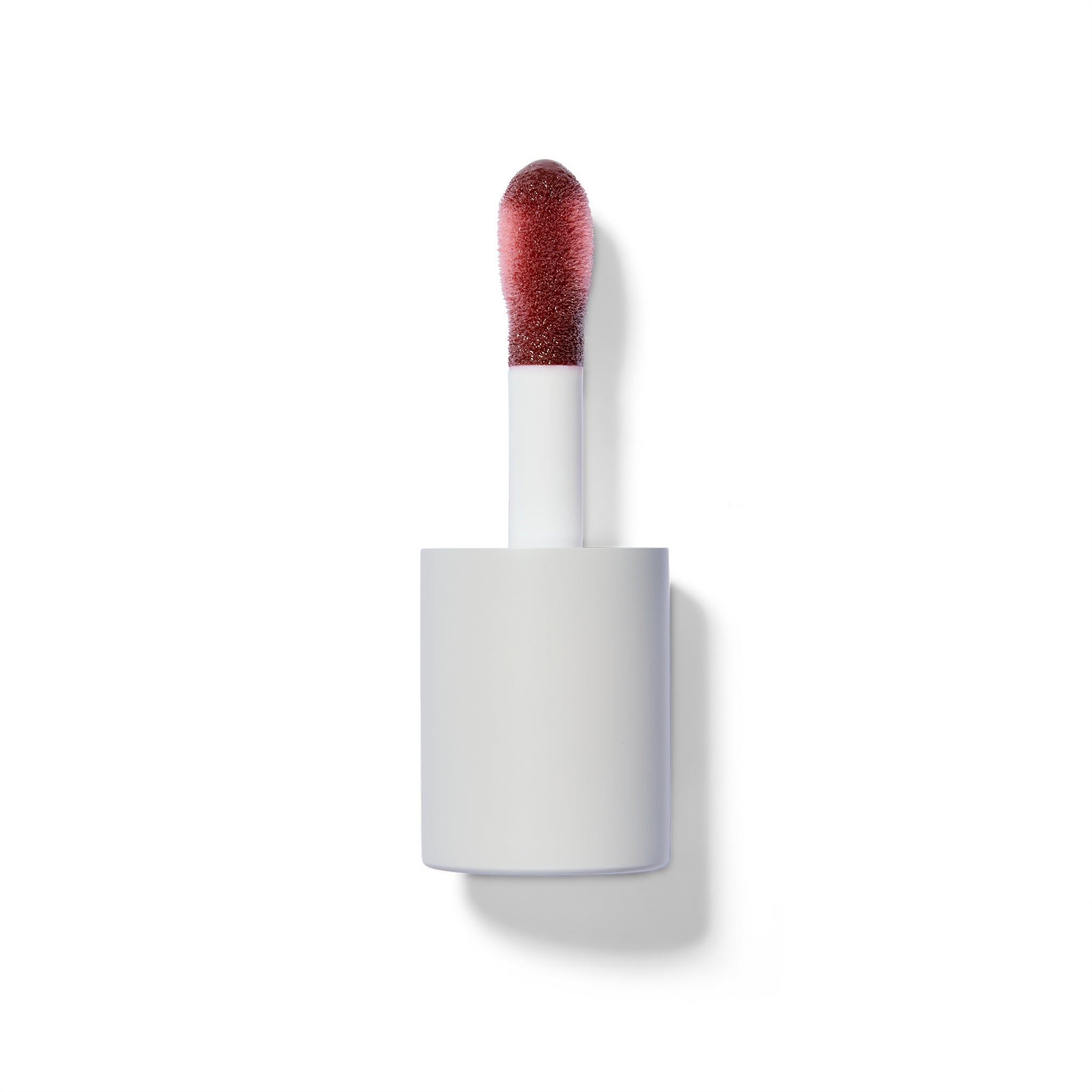 Berry lip tint applicator on a white background