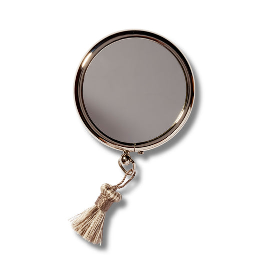 Arpin Hand Bag Mirror from the front. The  silver grey tassel is on the bottom of the mirror.