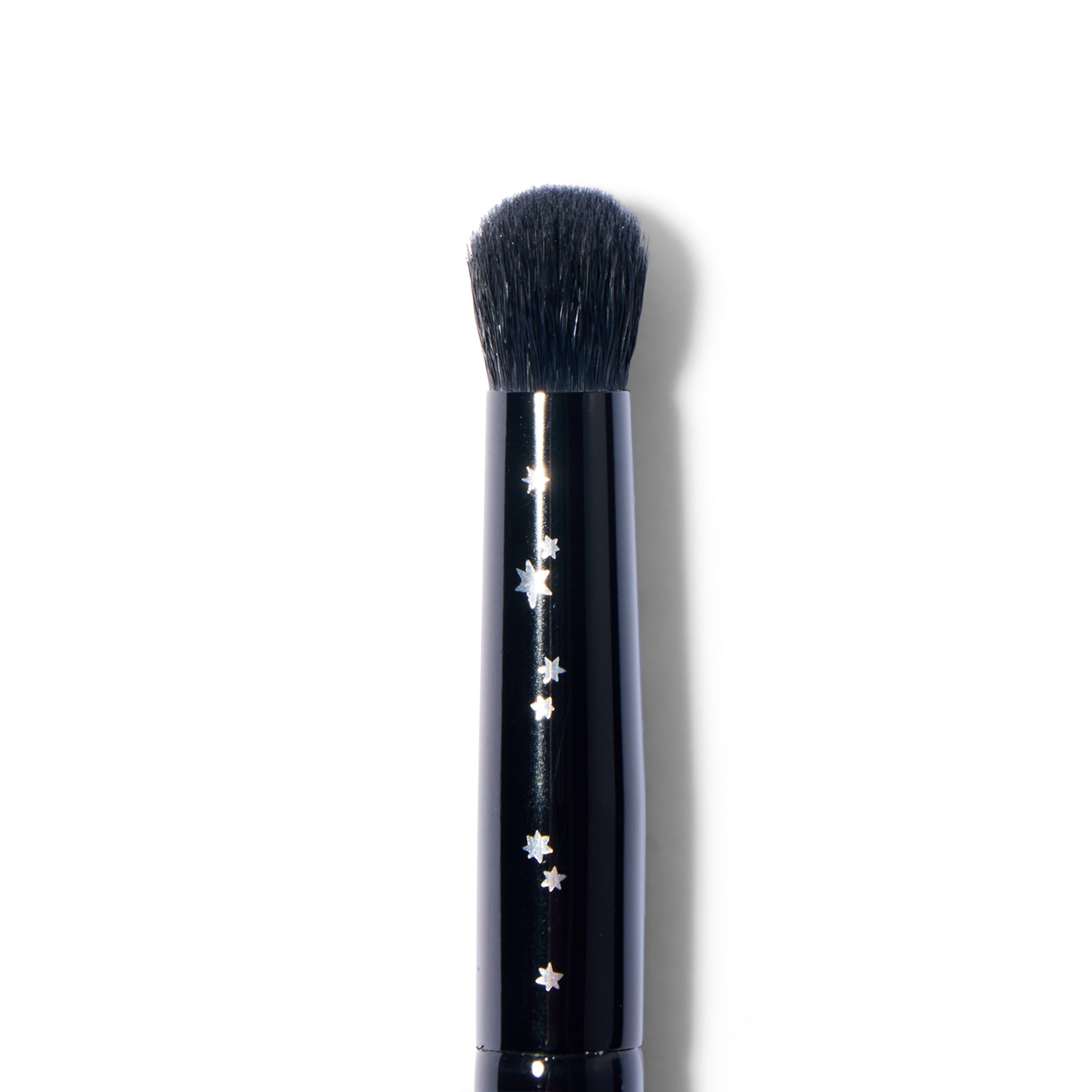 Makeup brush with decorative star pattern on a black handle against a white background
