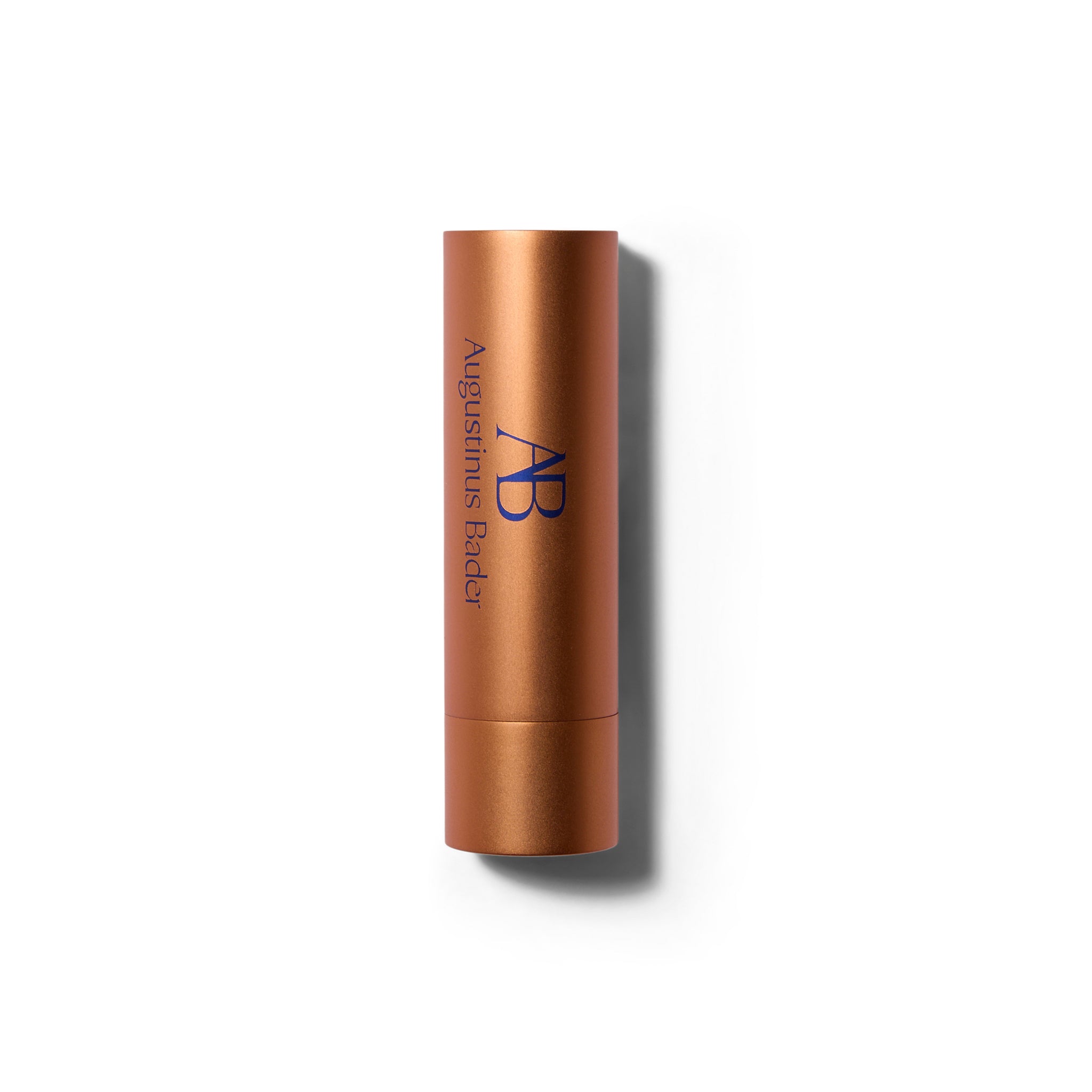 A matte metallic orange lipstick tube with the cap on. The font is a deep blue.