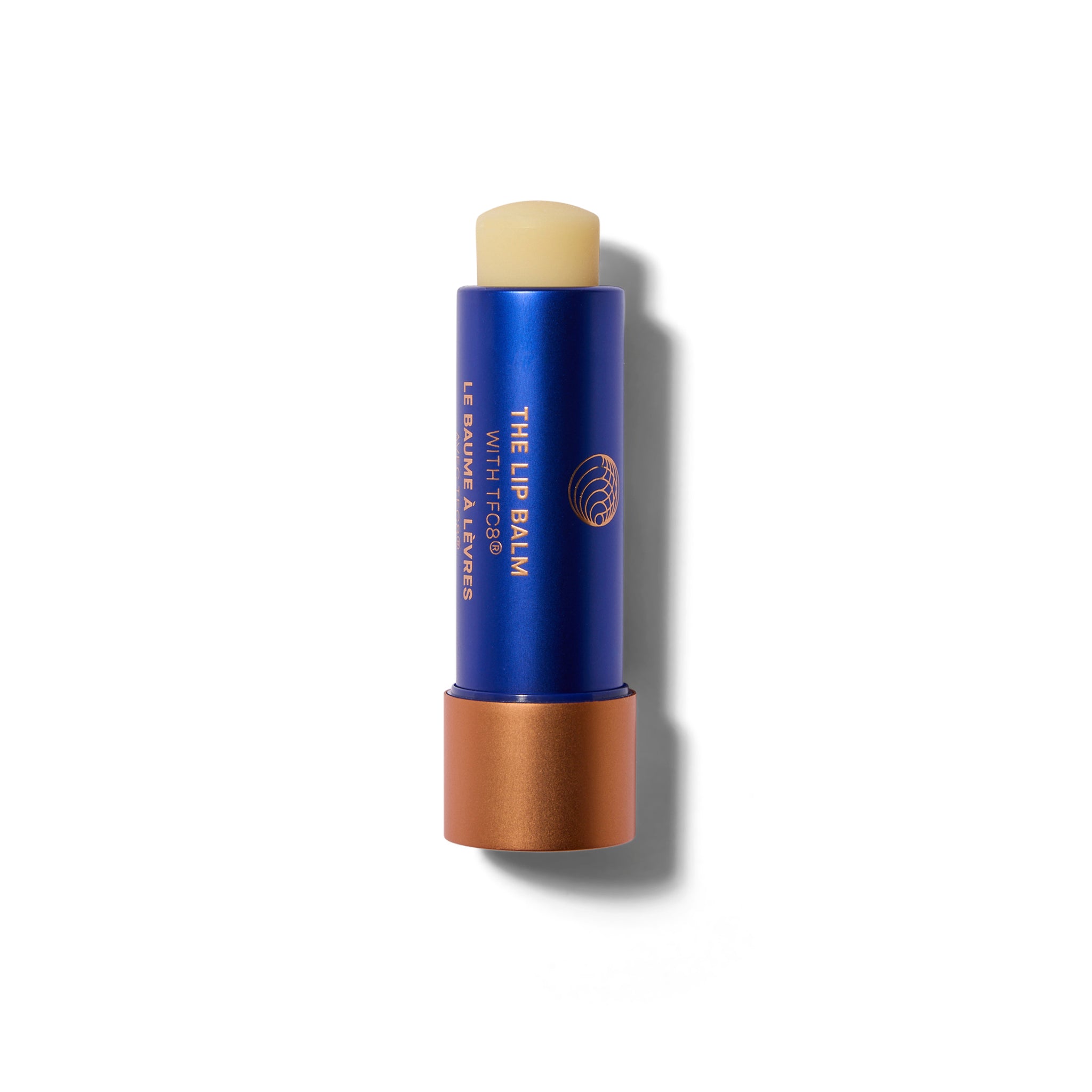 A waxy lip balm stick in a blue and matte metallic tube. The cap is off. The lip balm is wound up slightly so you can see the balm bullet.