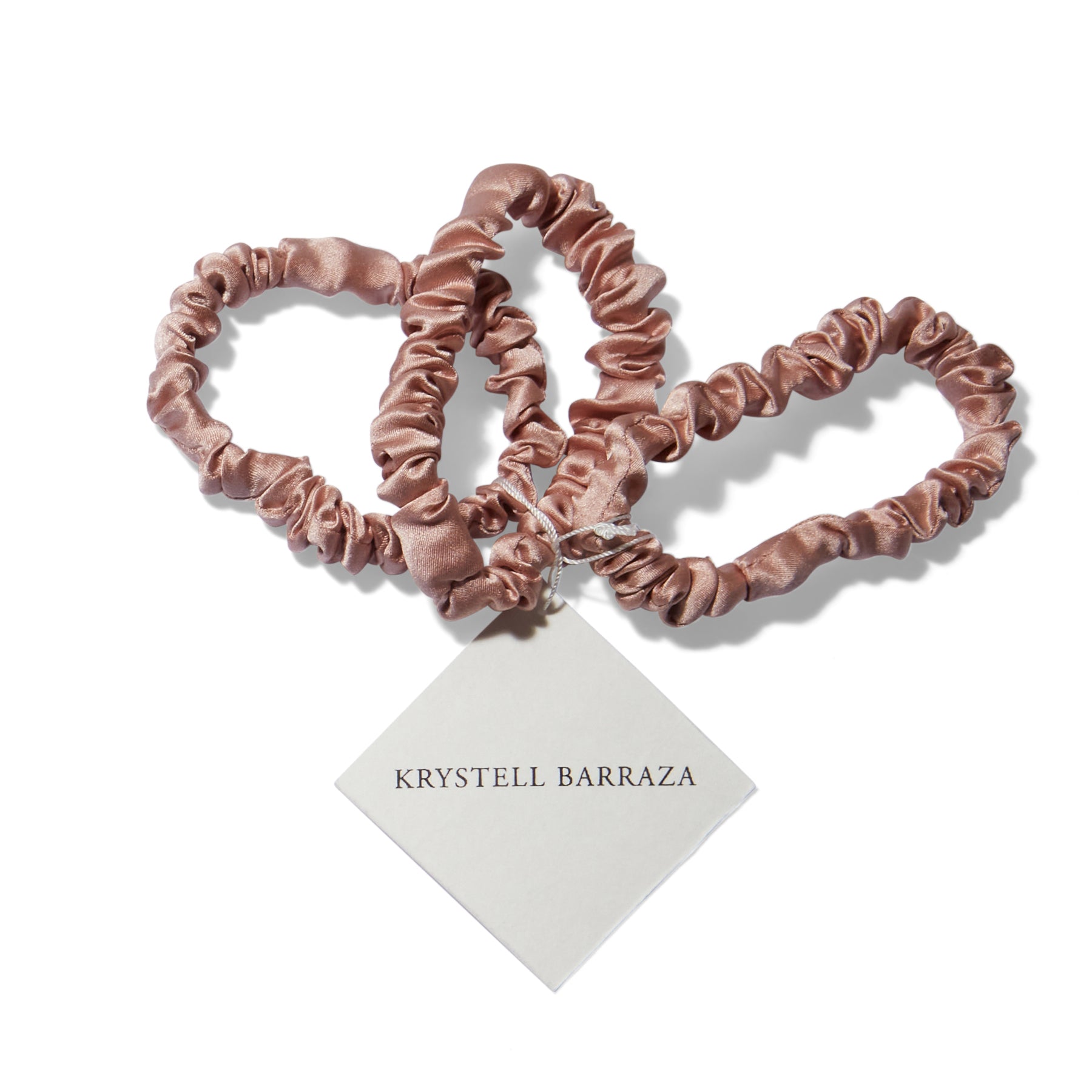 Three 6 Krystell Barraza silk hair ties in Mauve with the logo tag attached.