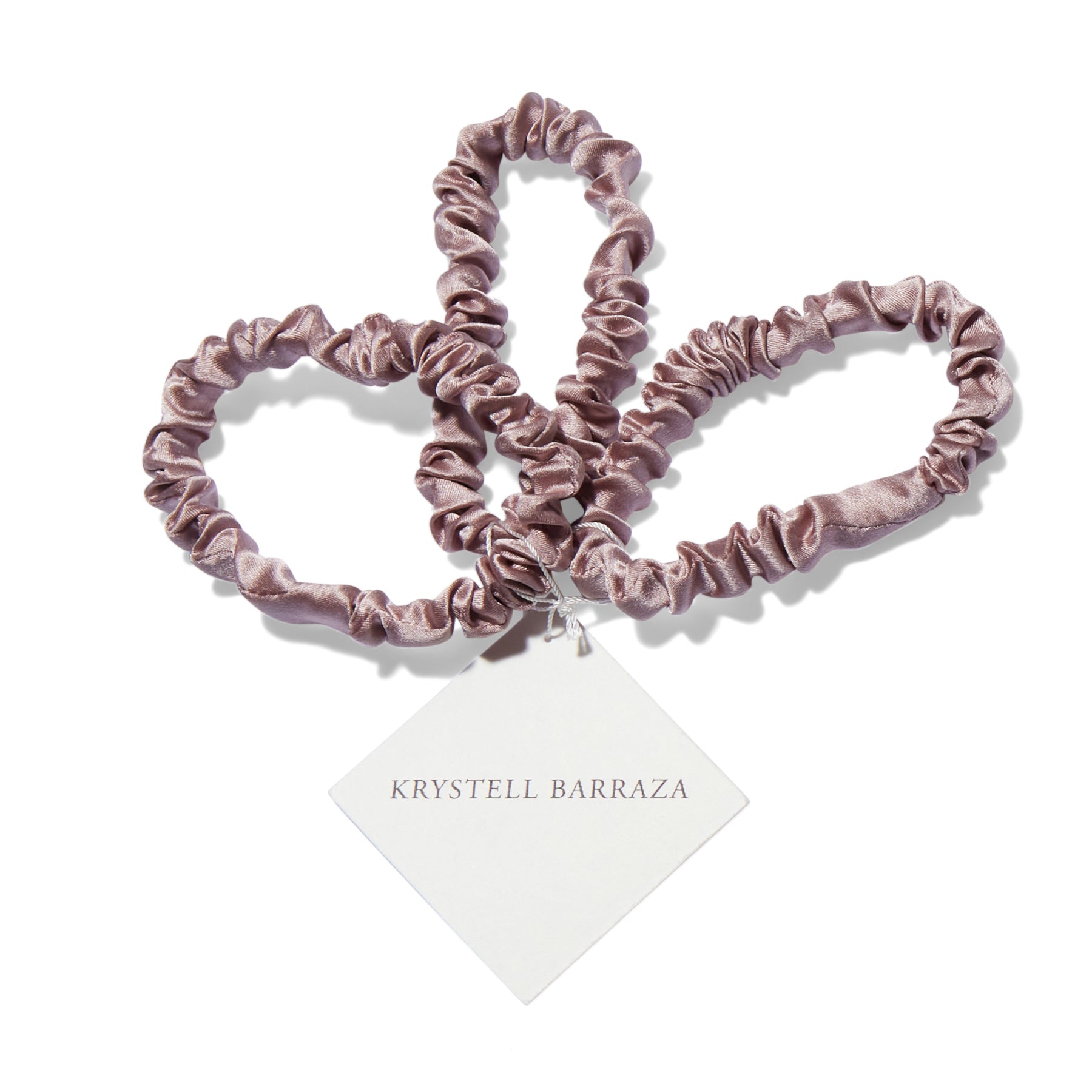 Three 6 Krystell Barraza silk hair ties in Rose with the logo tag attached.