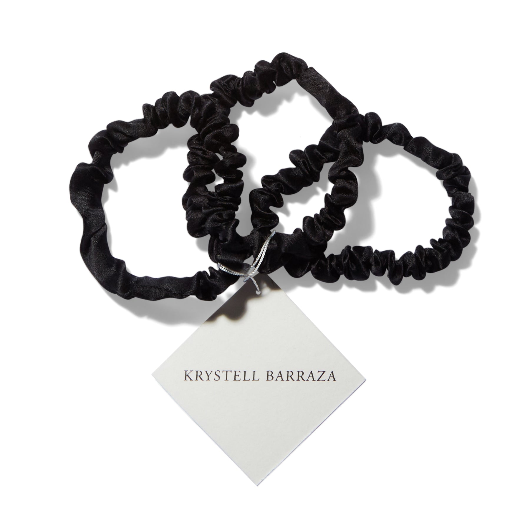 Three 6 Krystell Barraza silk hair ties in Onyx with the logo tag attached.