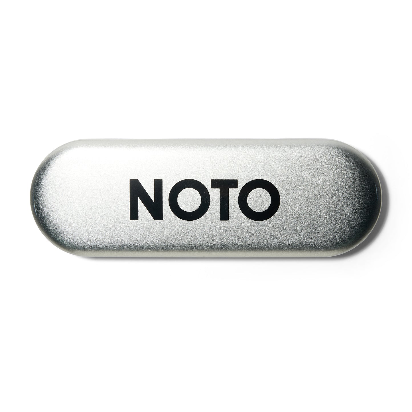 A closed oval silver metal case with Noto written in black on the top.
