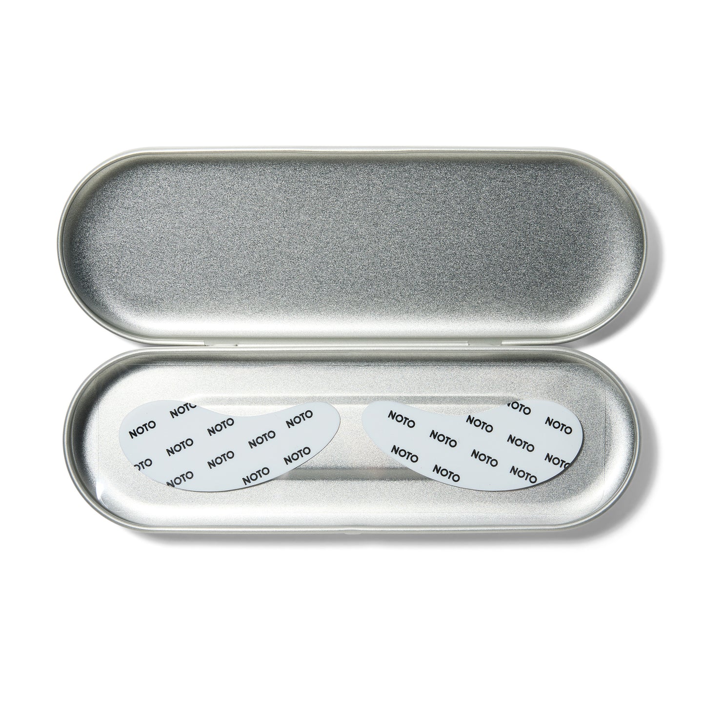 An open silver oval case with white tear drop shaped eye patches with Noto written on them.
