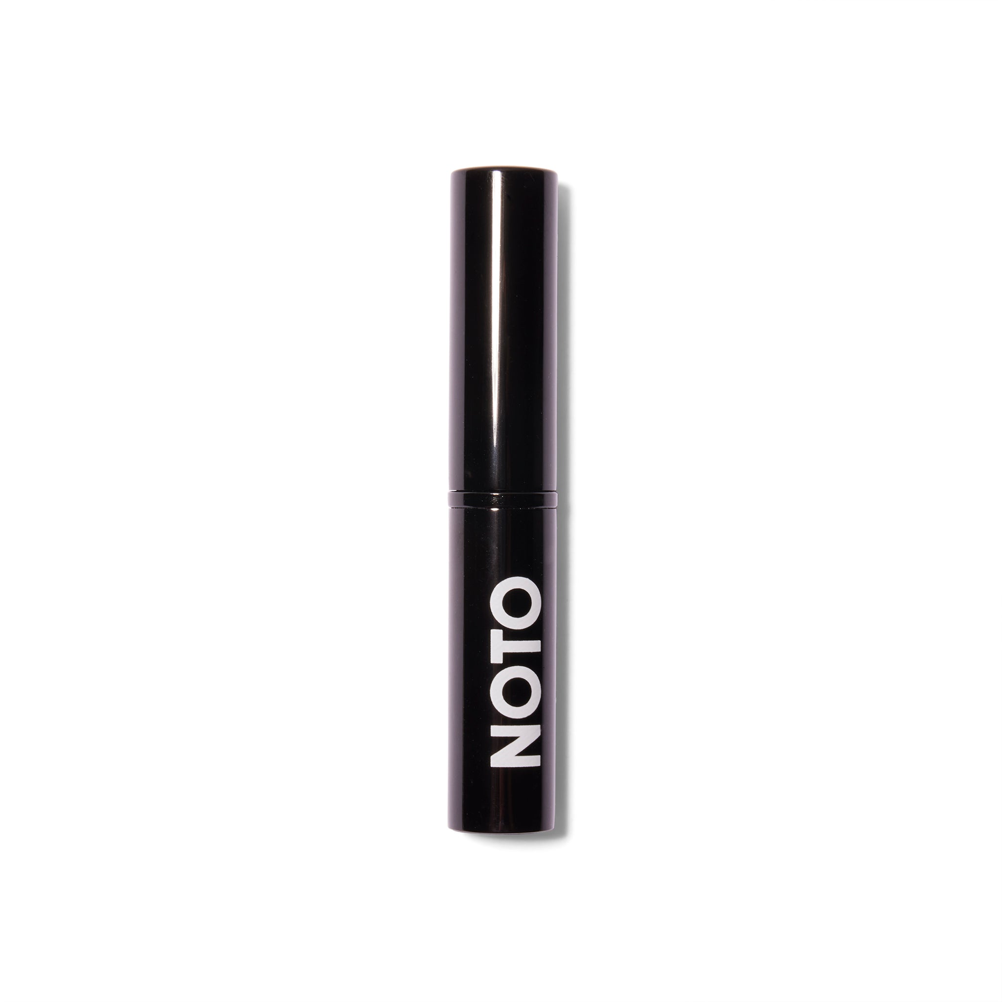 Front view of the Noto Organics Hydra Highlighter. The component is black with a white logo and the top is on the tube.