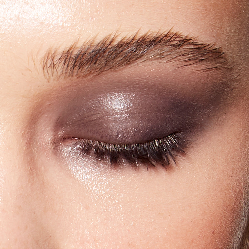 Image of a closed eye and fair skin wearing the Rituel de Fille Ash & Ember Eye Soot in Serpent De Mer, a deep purple color.