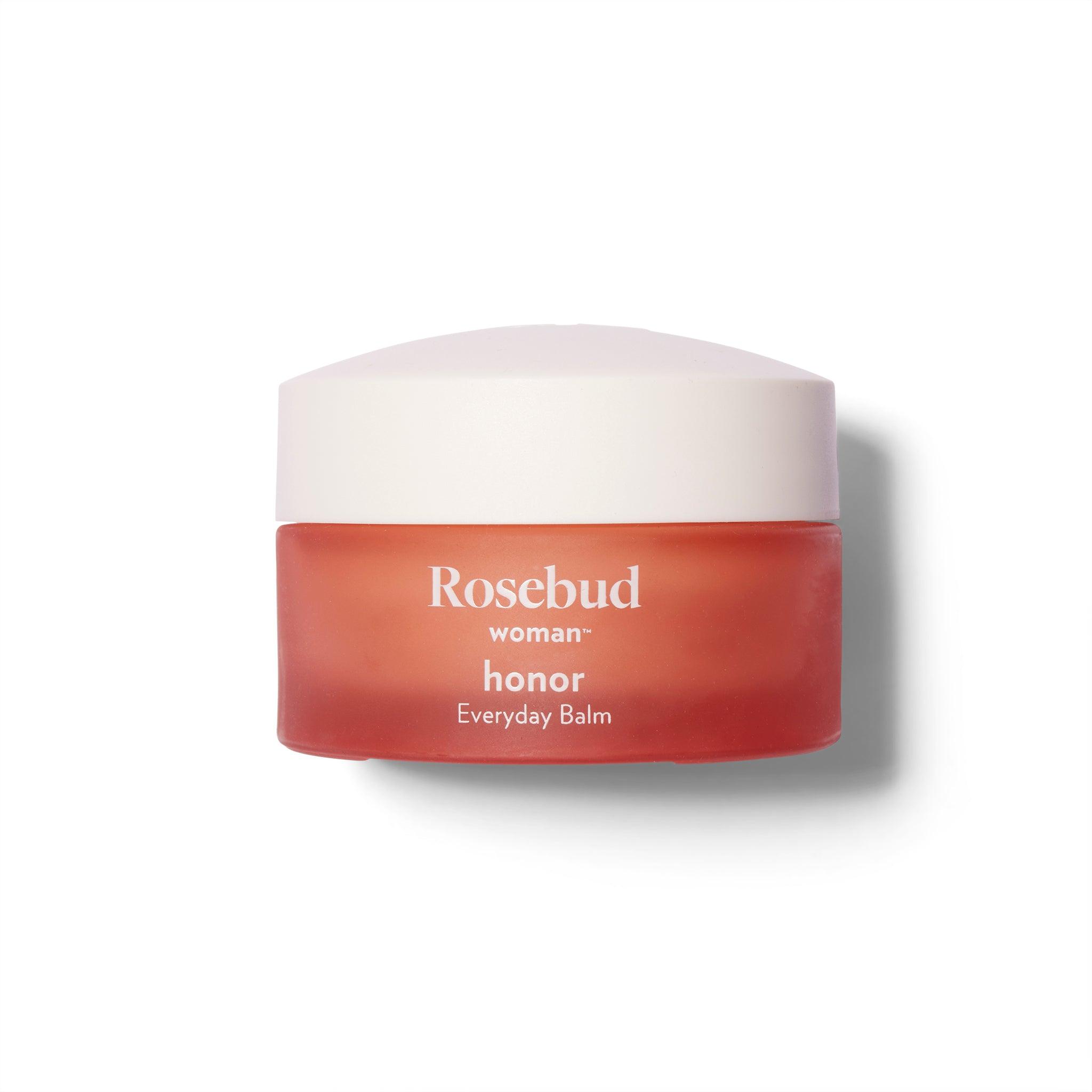 Front view of the Rosebud Woman Honor Balm. The jar is a rosy smoked glass with a domed white lid.