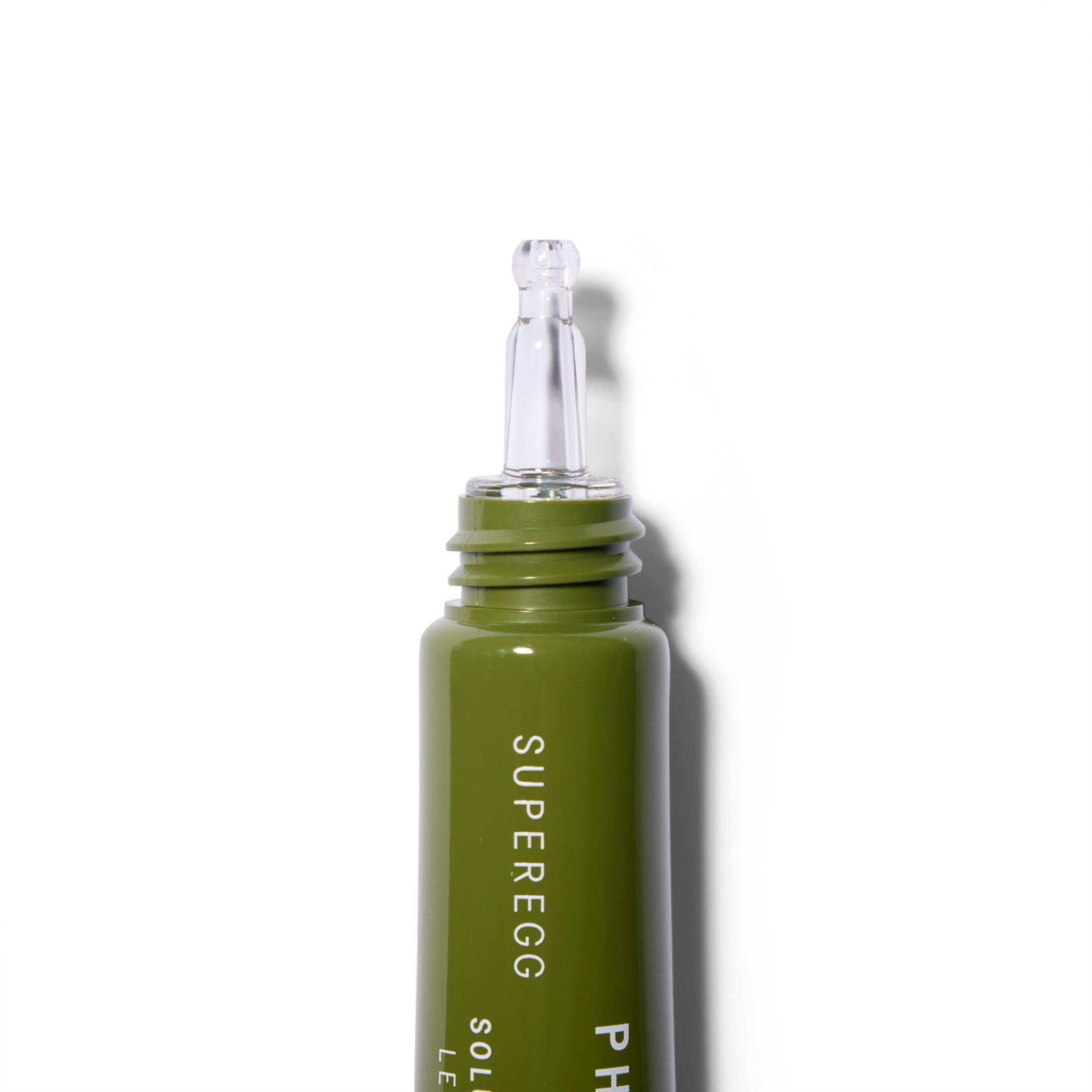 A close up of the tip of a green tube with white text. The cap is off and the tip is clear.