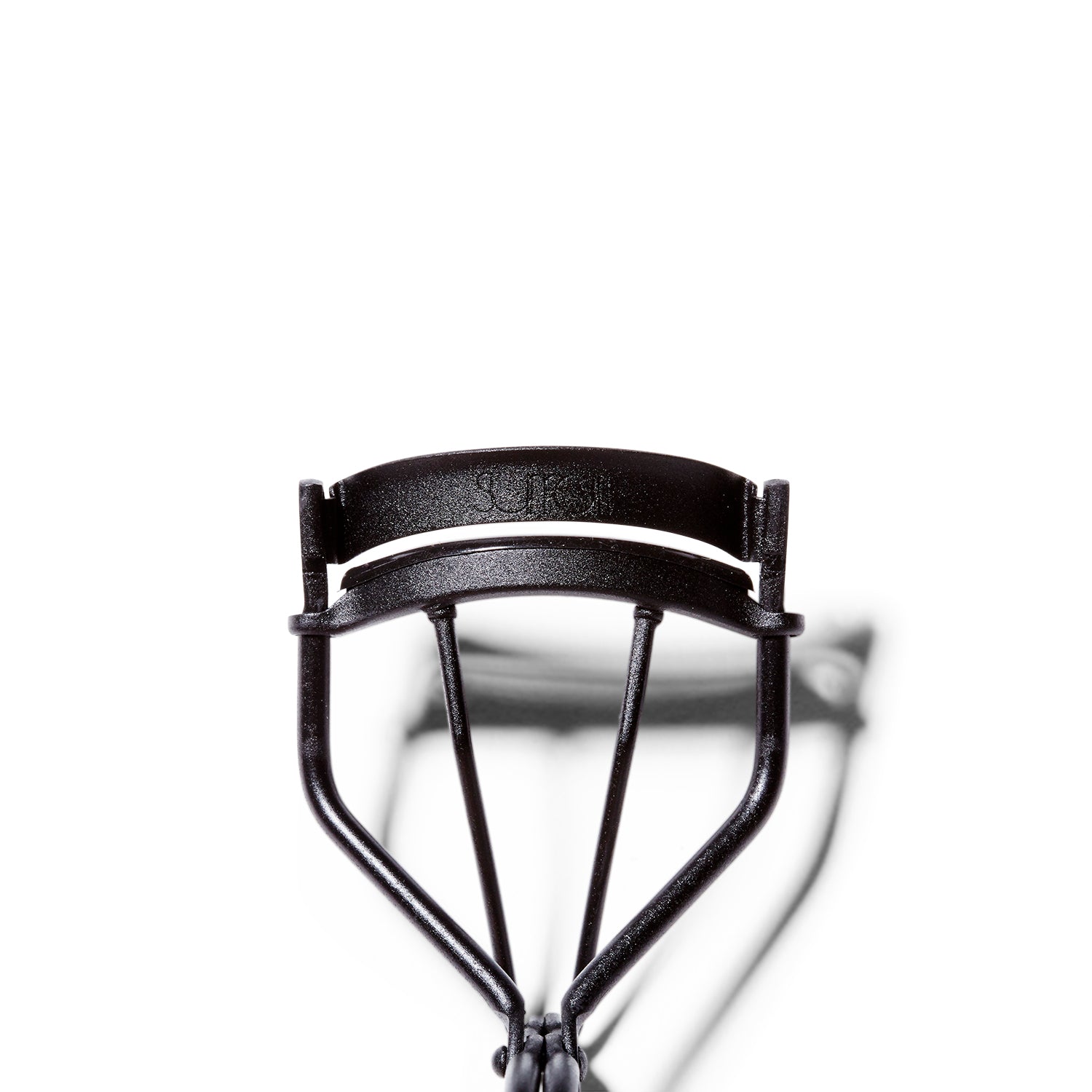 Close up of the matte black Surratt Relevee Eyelash Curler. The lash curler is very slightly open.