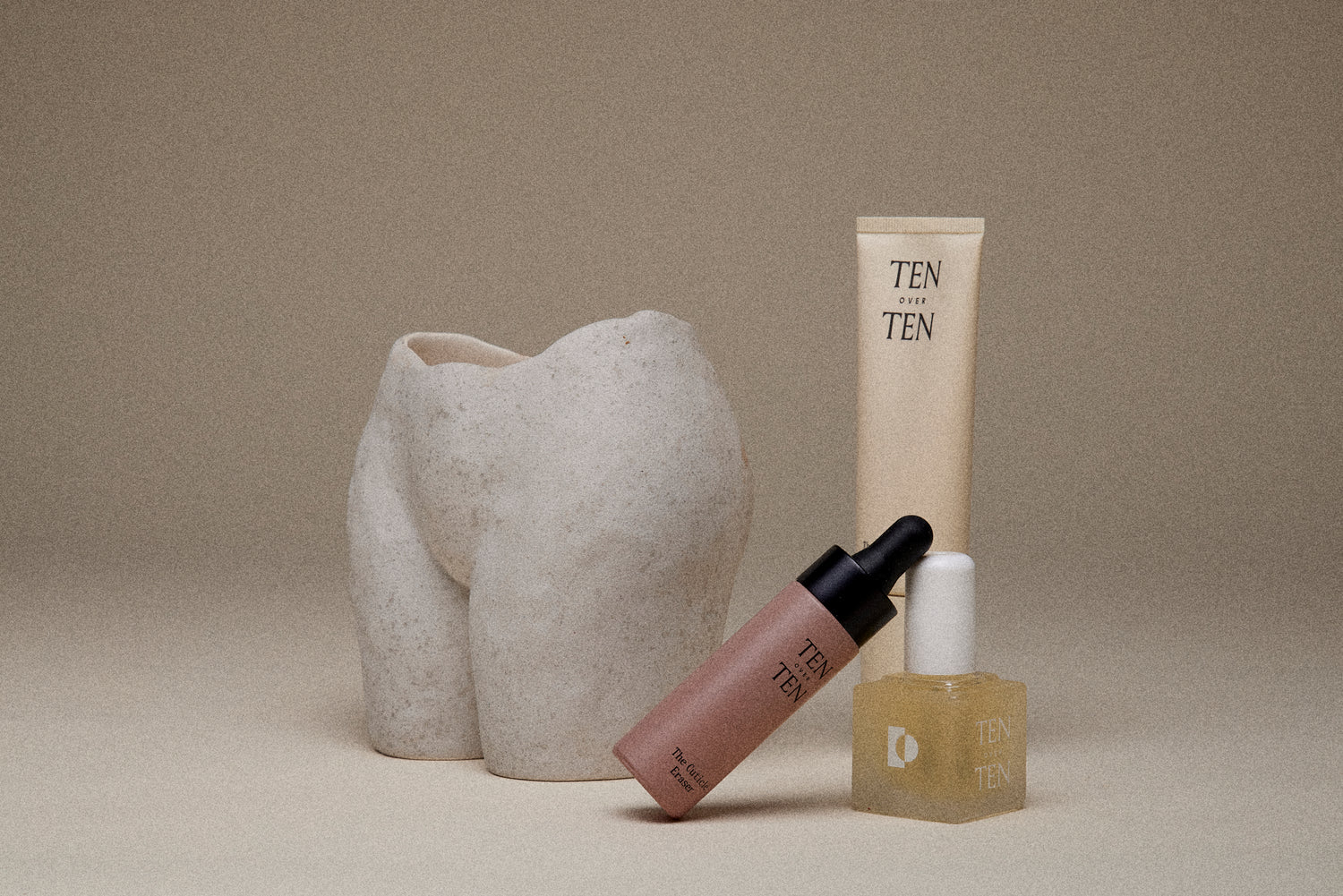 Three products from Ten Over Ten in front of a sculpture of a woman's torso
