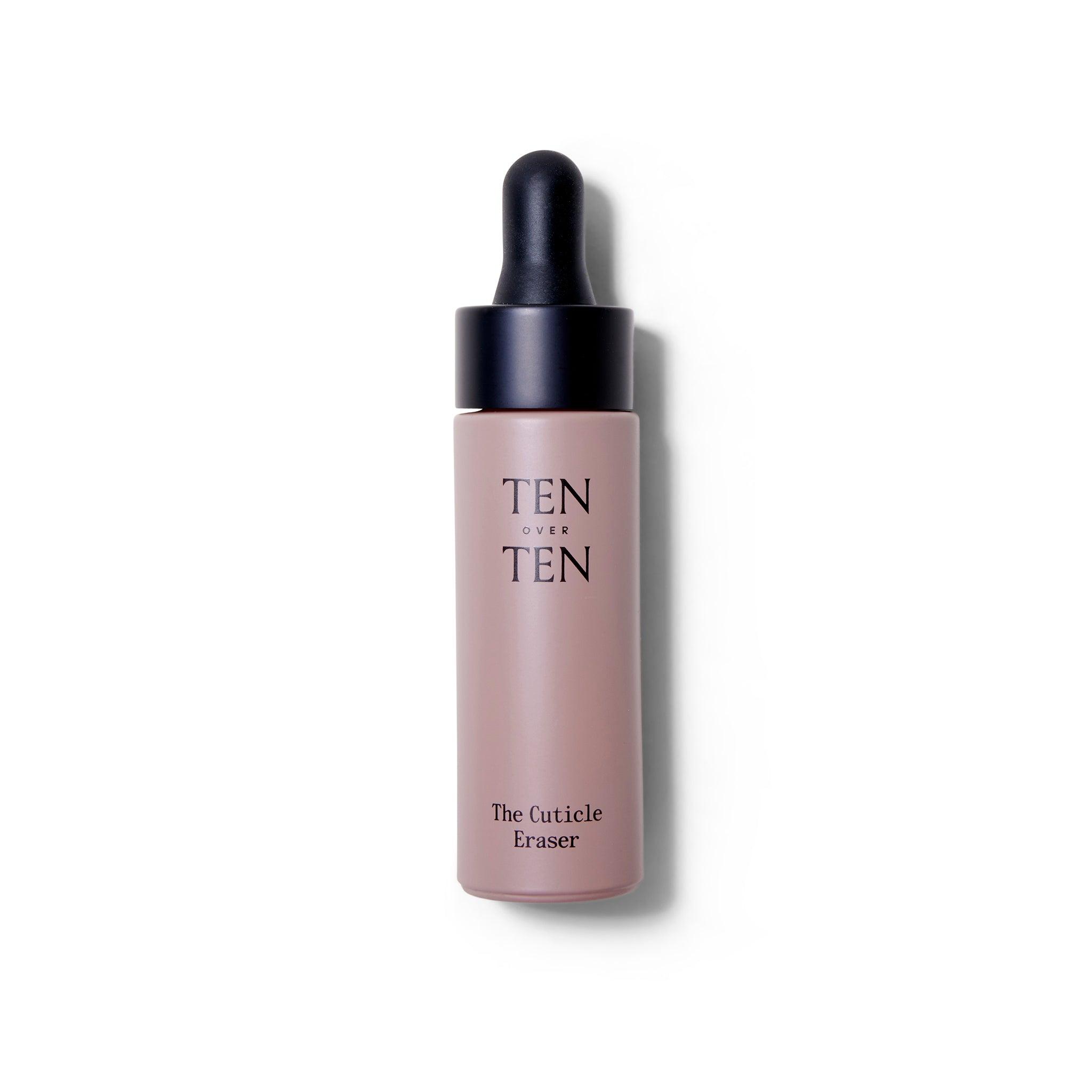 Bottle of the ten over ten The Cuticle Eraser. The bottle is a dusty pink with a black rubber dropper top. The top is on.
