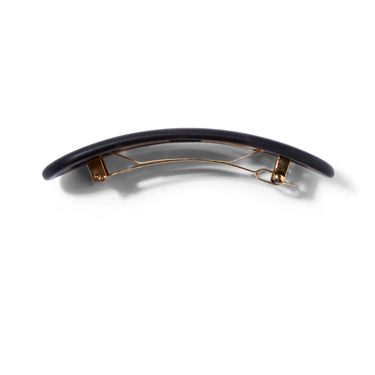 An side view of the matte black UNDO oval shaped hair clip that shows the gold hardware. 