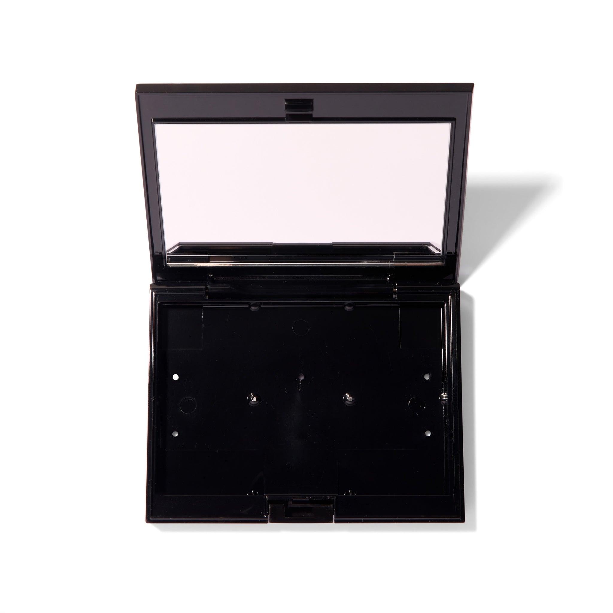 The black Compact Case II, open and showing the mirror and an empty interior. 
