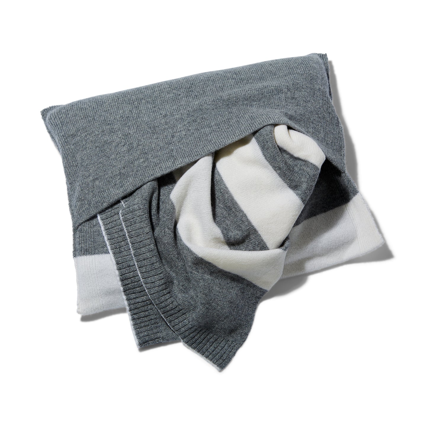 The Reed Clarke Cashmere Travel blanket, a folded grey blanket with wide white stripes shown in the cashmere envelope it comes in. 