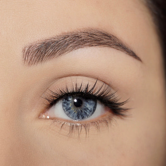 Close up of woman's eye with fair skin and blue eyes wearing the Dark Swan of Denmark Individual Feather Lashes.