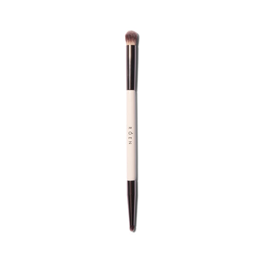 The Roen Everything Eye dual ended eyeshadow brush. One side has a smaller tapered tip and the other is fluffier and dome shaped.