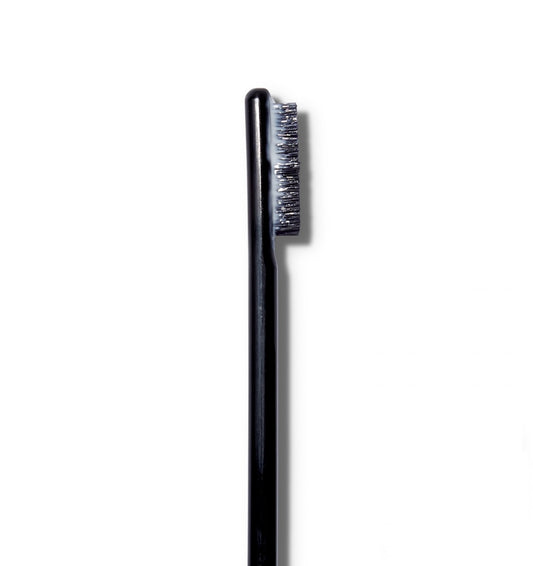 A close up of the The Surratt Expressioniste brow pomade brush with product on it. 