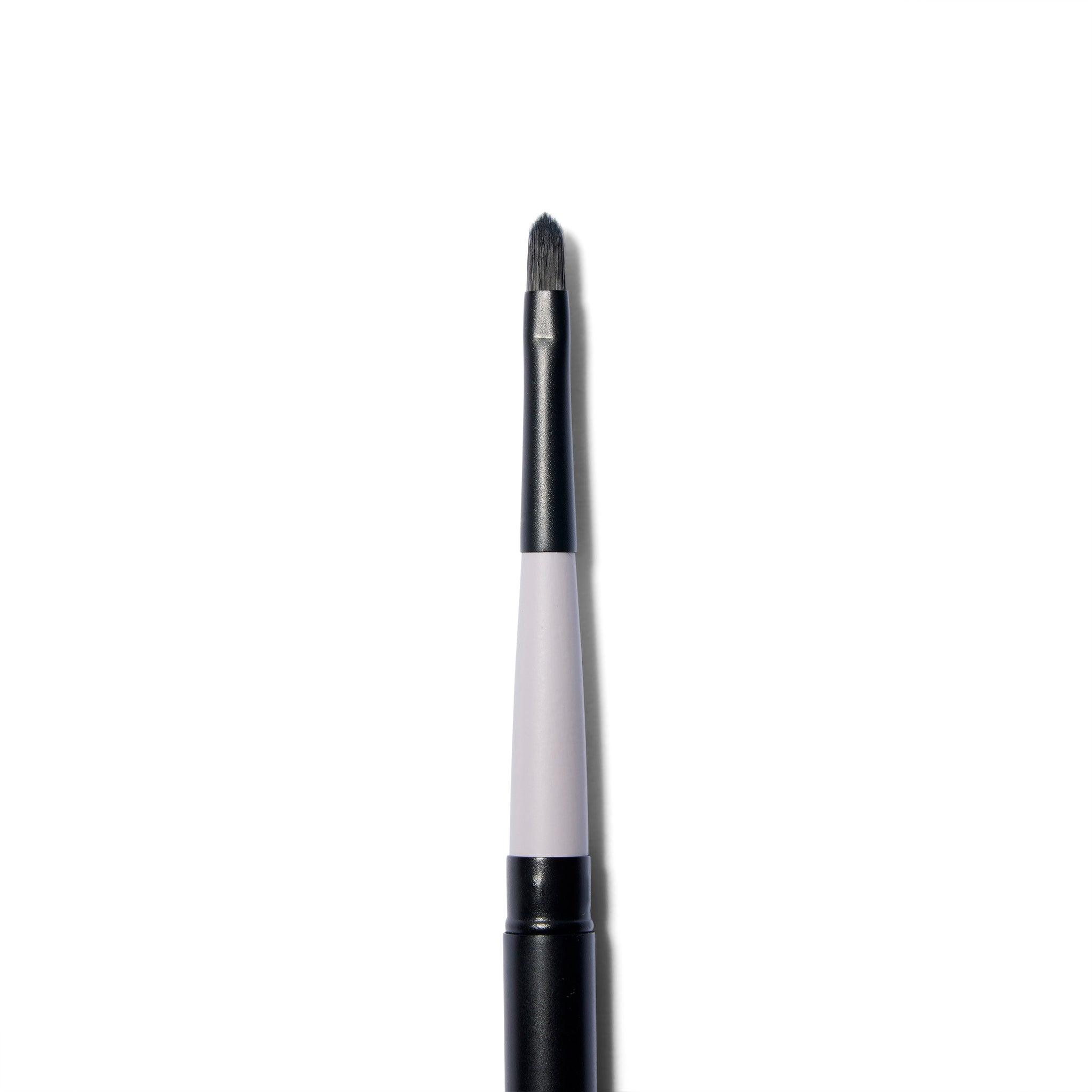 A close up of the  brush of the  fine tipped application brush. The brush hairs are black and slightly tapered. 