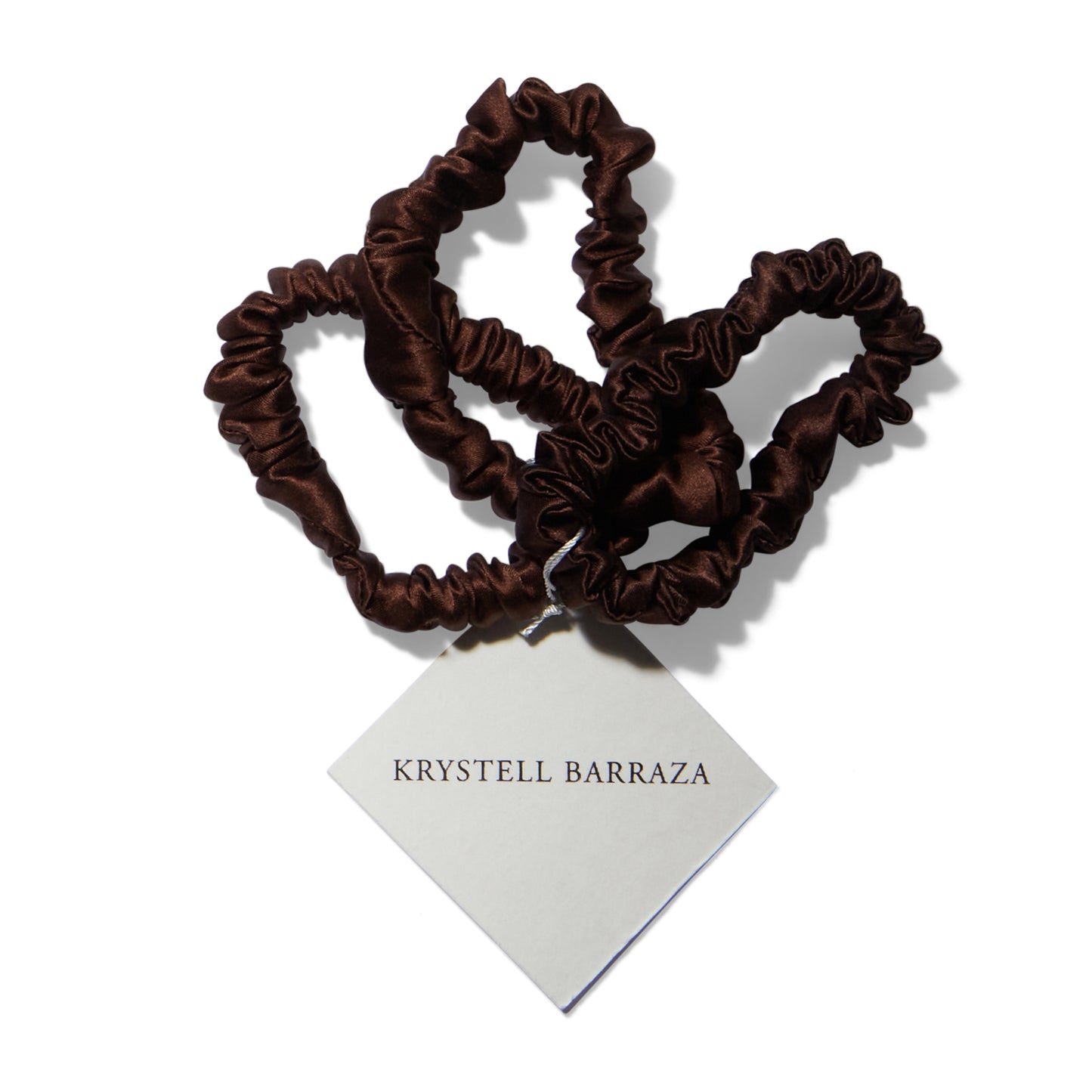 Three 6 Krystell Barraza silk hair ties in Cocoa with the logo tag attached. 