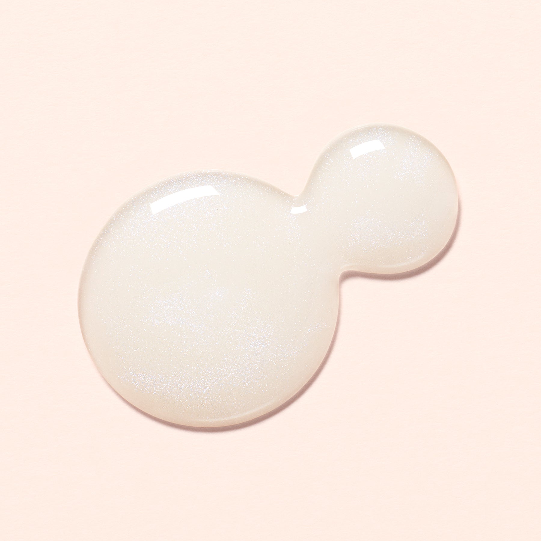 A dollop of the Active Bright - a milky opal color - nail polish on a light peach background.