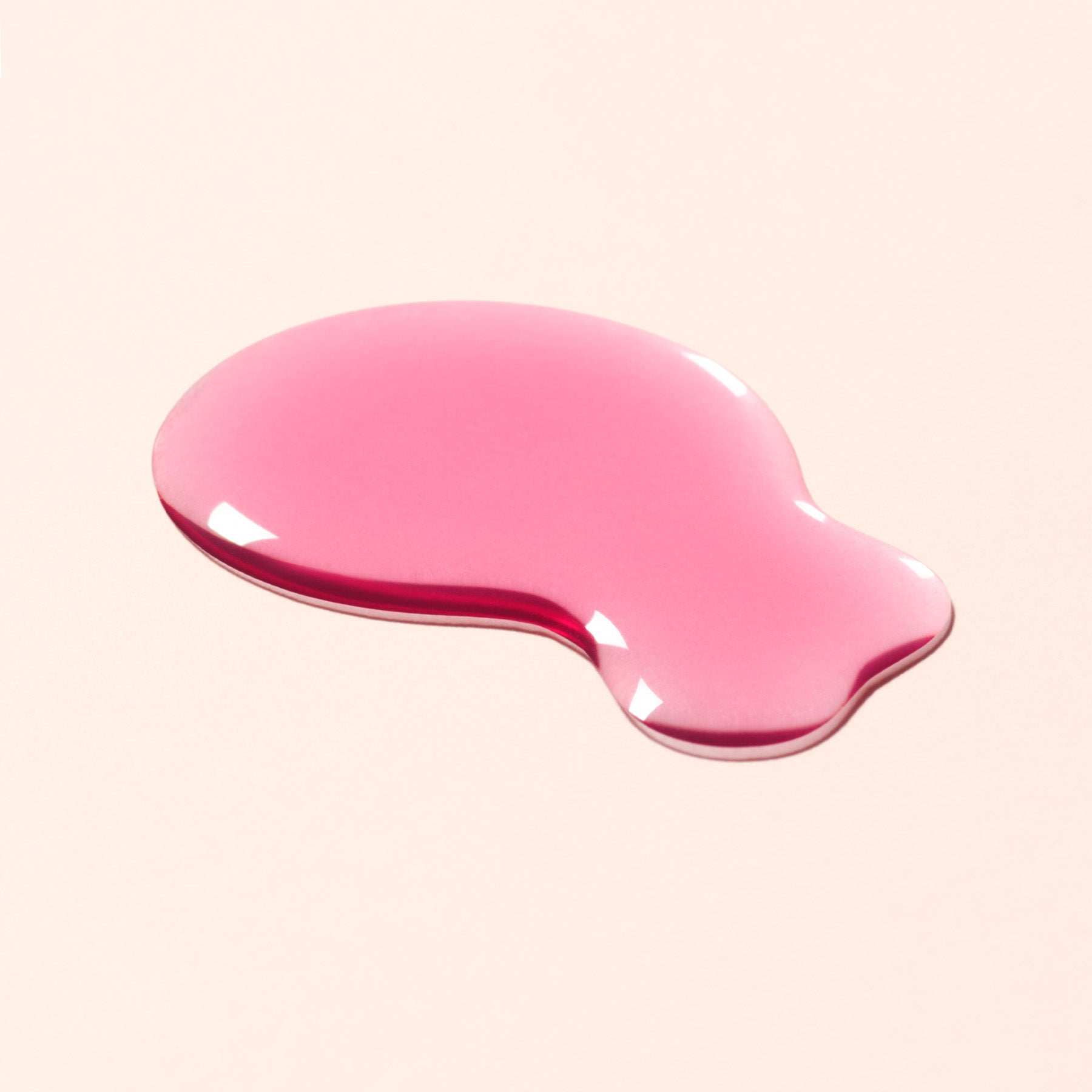 A dollop of the Active Glow Blueberry - a transparent cool-pink shade - nail polish on a light peach background.