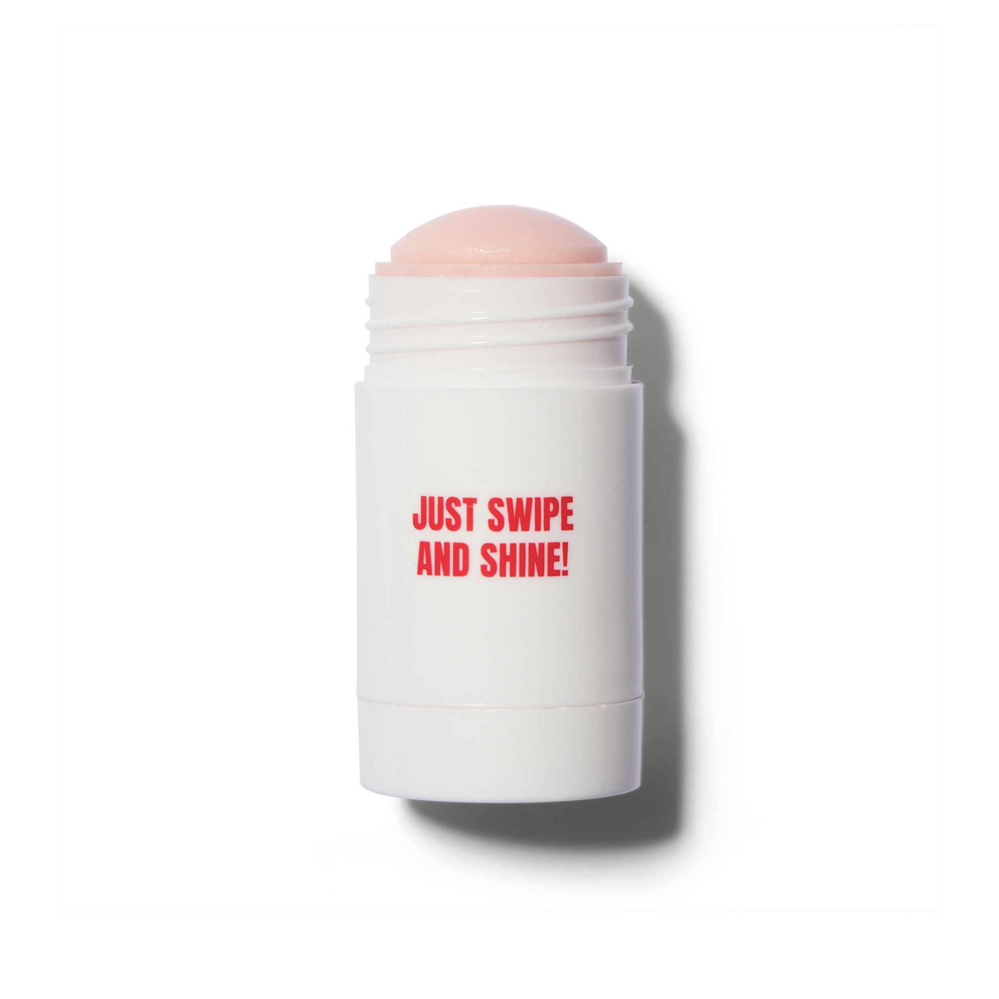 A white cylindrical cosmetic stick container with a little pink product showing, featuring the red text 'JUST SWIPE AND SHINE!' on the front, set against a plain white background with a soft shadow.