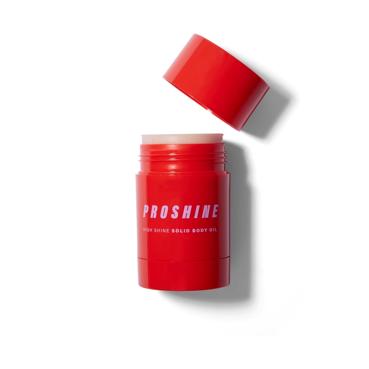 Front view of the Proshine Solid Body Oil. The packaging is a shiny red cylinder with light lavender text.  The lid is unscrewed and off to an angle on the right. The product is wound up out of the tube and showing a bit. The solid product is a creamy off white.