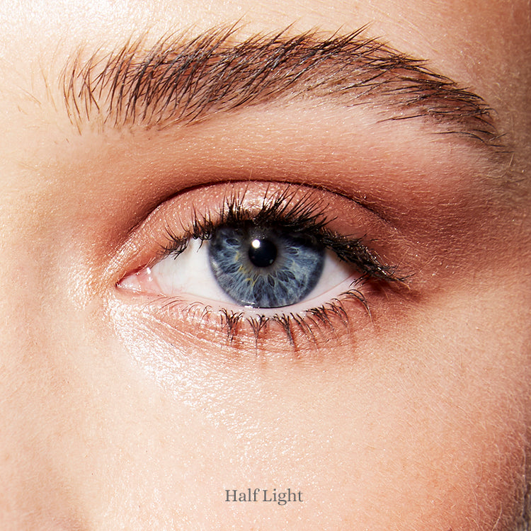 Image of an open blue eye and fair skin wearing the Rituel de Fille Ash & Ember Eye Soot in Half Light. 