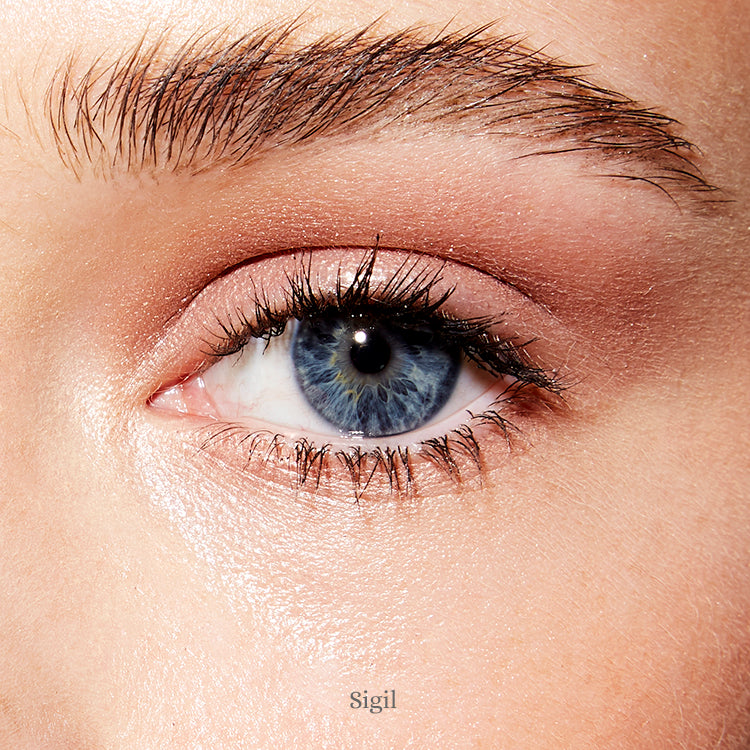 Image of an open blue eye and fair skin wearing the Rituel de Fille Ash & Ember Eye Soot in Sigil. 