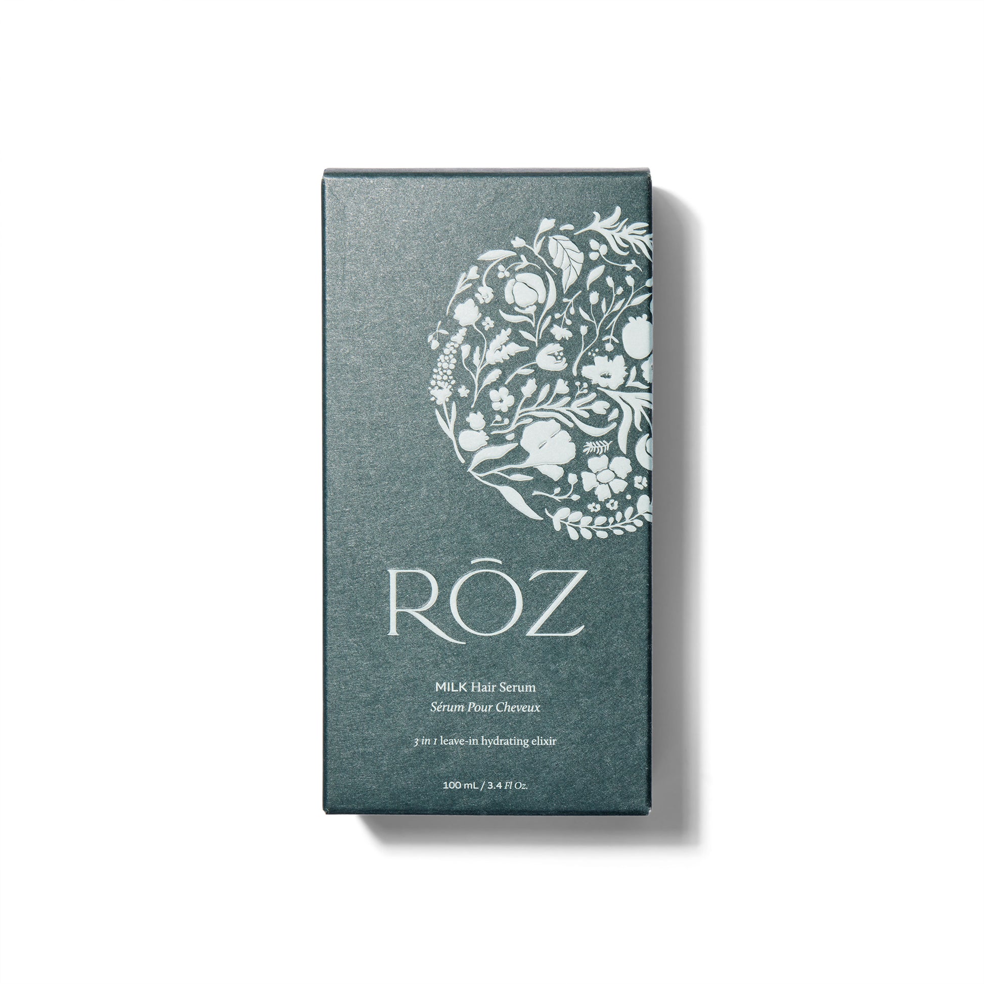 The box for the ROZ Milk Serum. The box is a deep green with a raised illustration of flowers in a circle. 