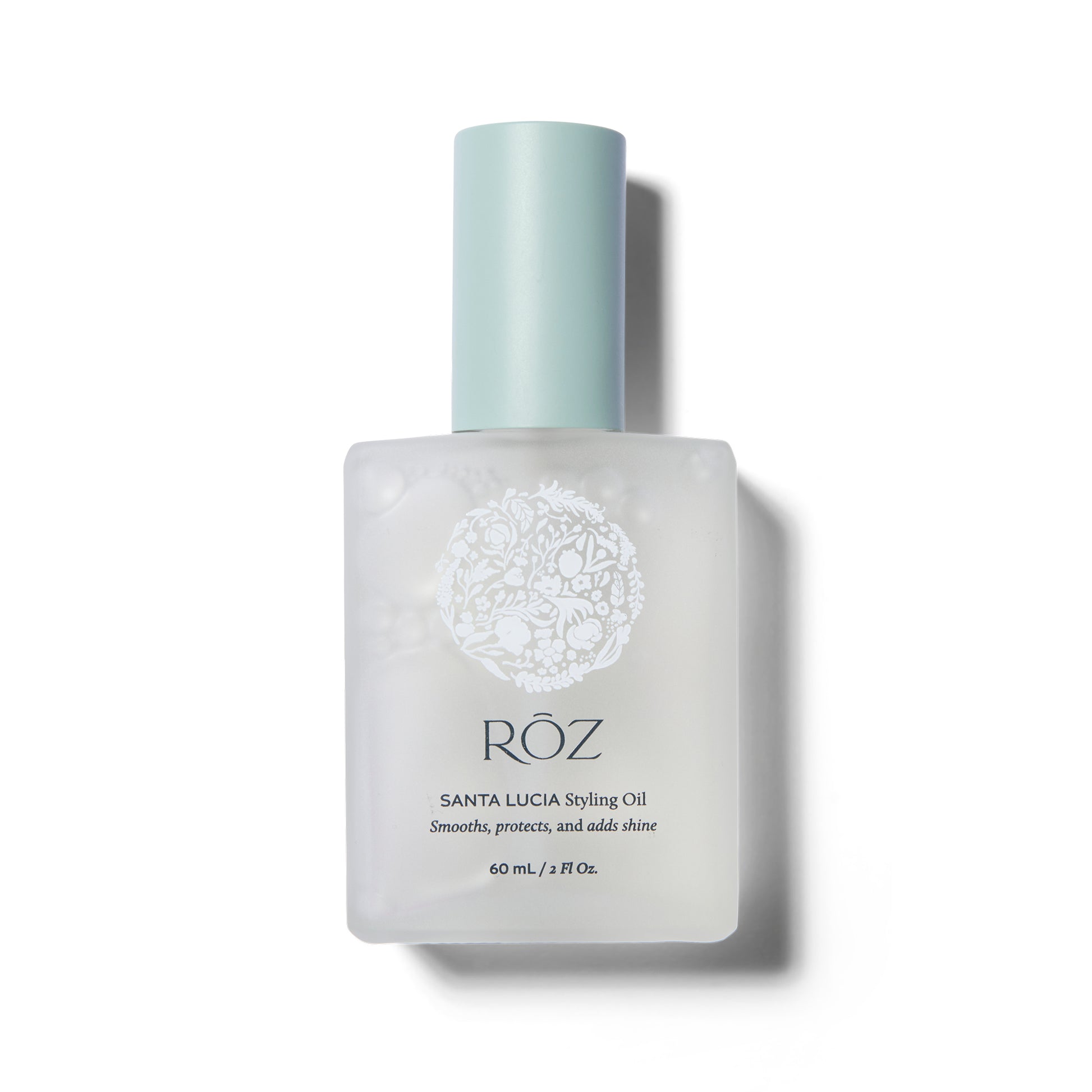 Front view of the ROZ Santa Lucia Styling Oil. The white frosted bottle has a pale blue cap. The cap is on.