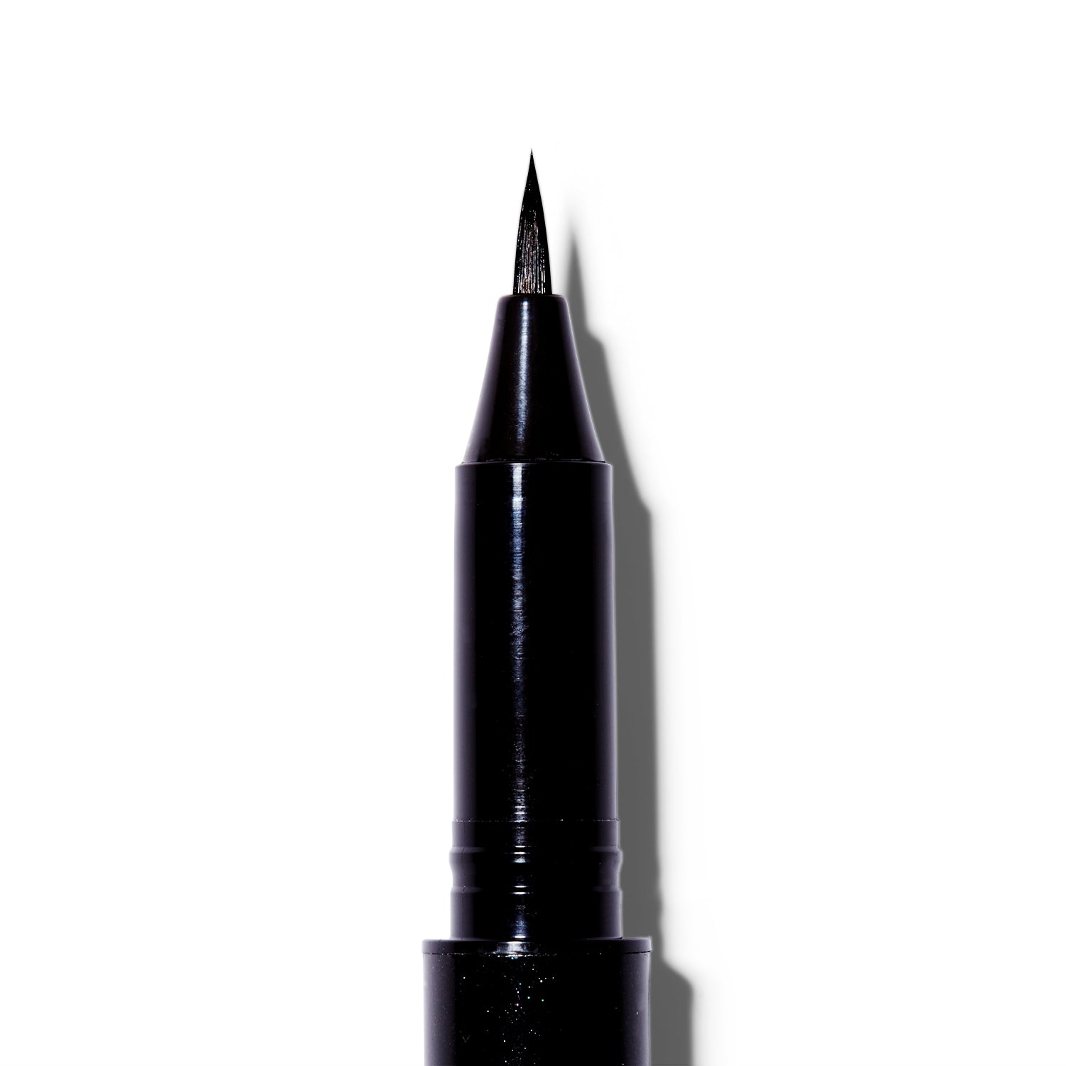  A close up of the Surratt Autographique Liquid Eyeliner in Chat Noir, a deep black. The pen is made of individual hairs and goes to a sharp point.