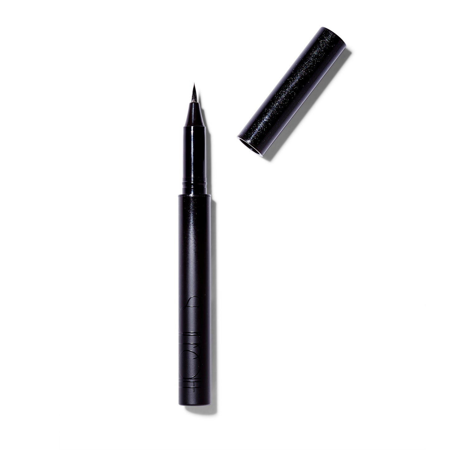 The Surratt Autographique Liquid Eyeliner Pen in Chat Noir, a deep black. The cap of the pen is off and at an angle on the right side of the pen. The pen is made of individual hairs and goes to a sharp point.