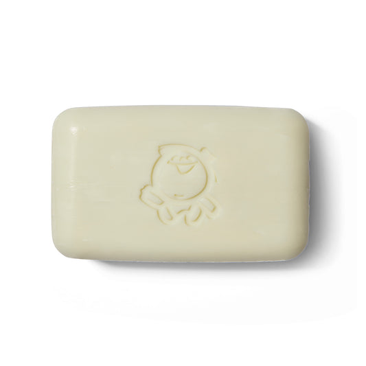 The Takeda Brush Purely Soap out of its outer packaging. There is a caricature of a person embossed on the soap.