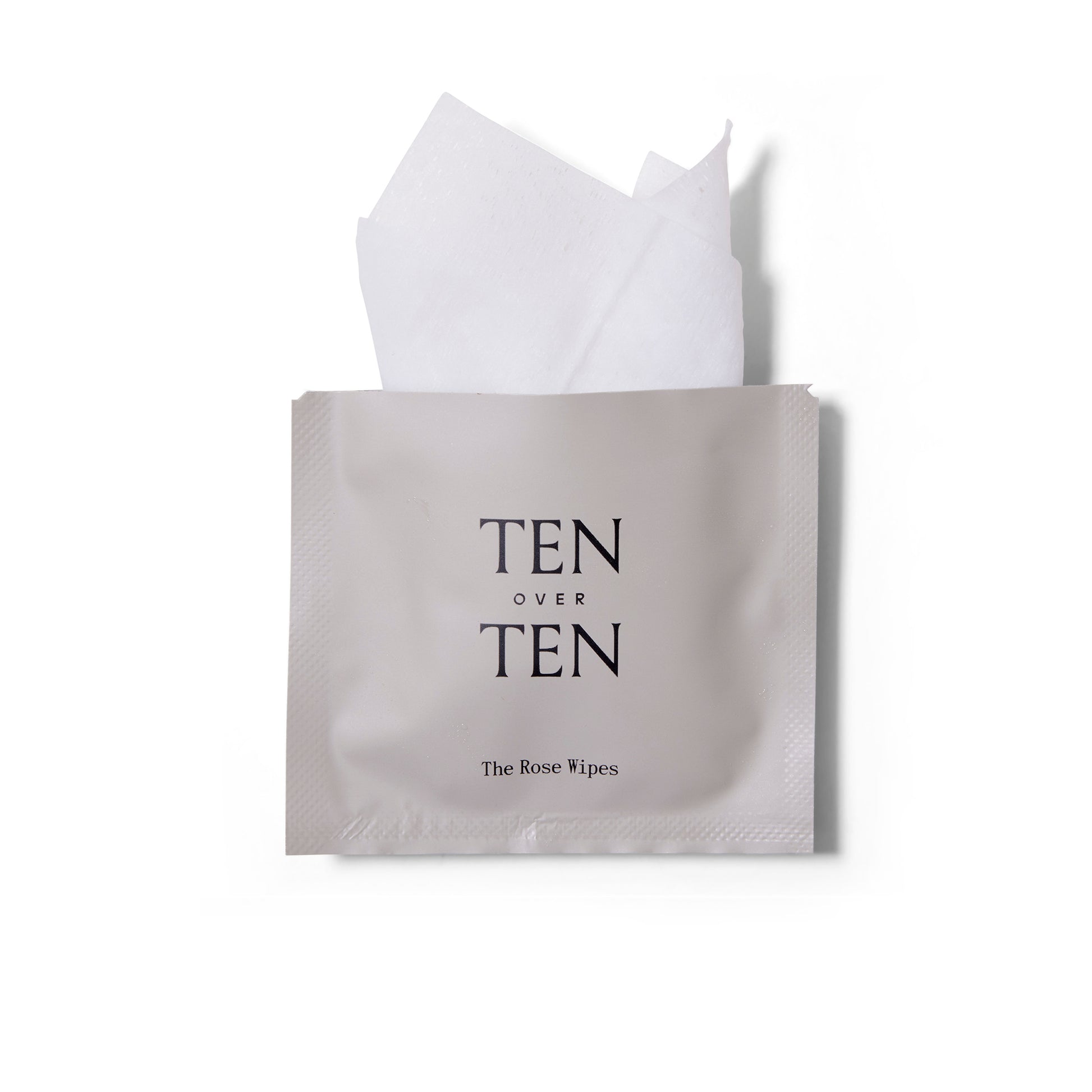 an open sachet of The Rose Wipes nail polish remover from ten over ten. The towelette is poking out of the opening.