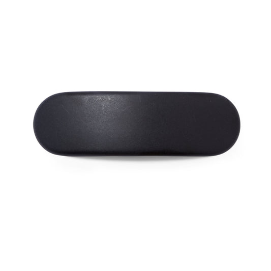 An overhead view of the matte black UNDO oval shaped hair clip. 