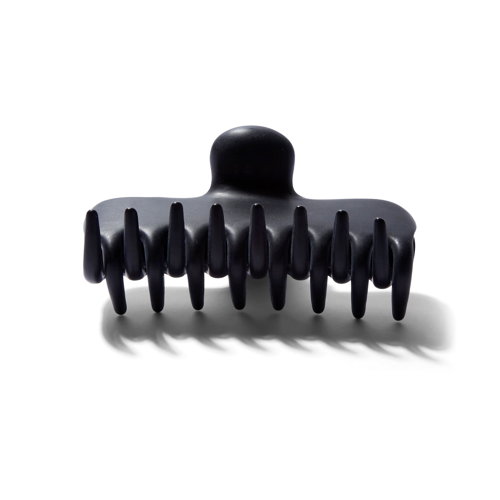 Side view of the Undo 4 inch matte black colored claw clip.
