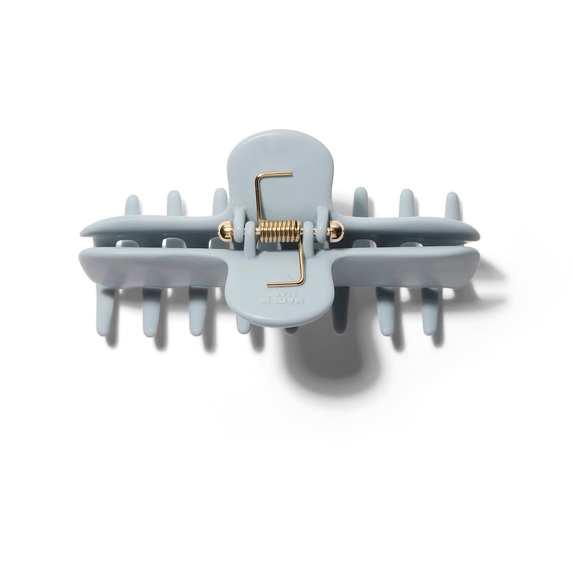 Top view of the Undo 4 inch matte pale blue colored claw clip showing the elegant gold spring.