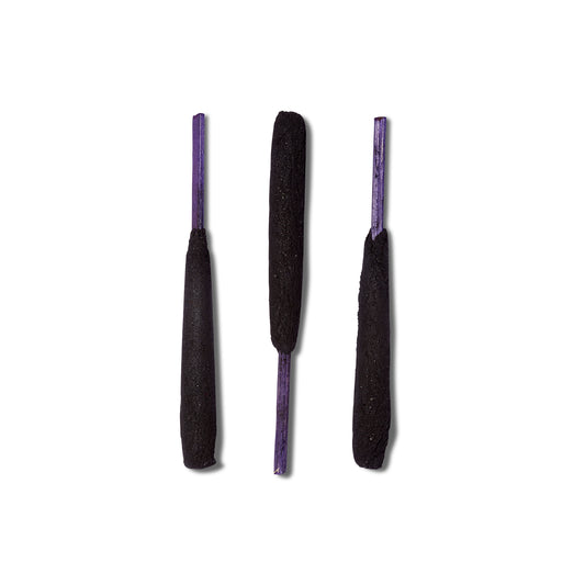 Three sticks of the Holy Smoke incense from Zen Bunni. The incense is thick and a deep black color with purple wooden sticks.  